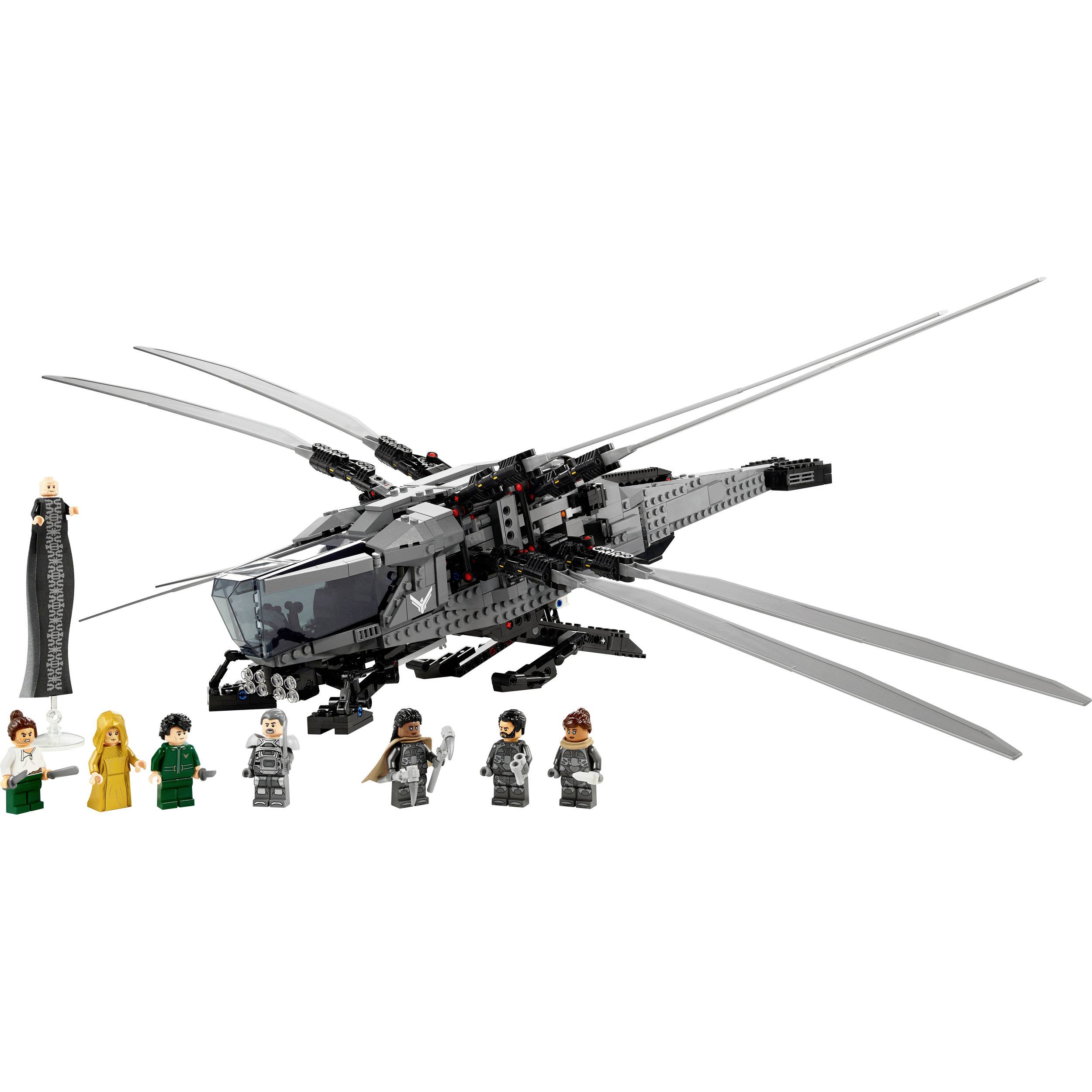 Een modelbouwset van een futuristisch vliegtuig met figuren in kostuums. Het toont een gedetailleerd helikoptermodel met toebehoren.