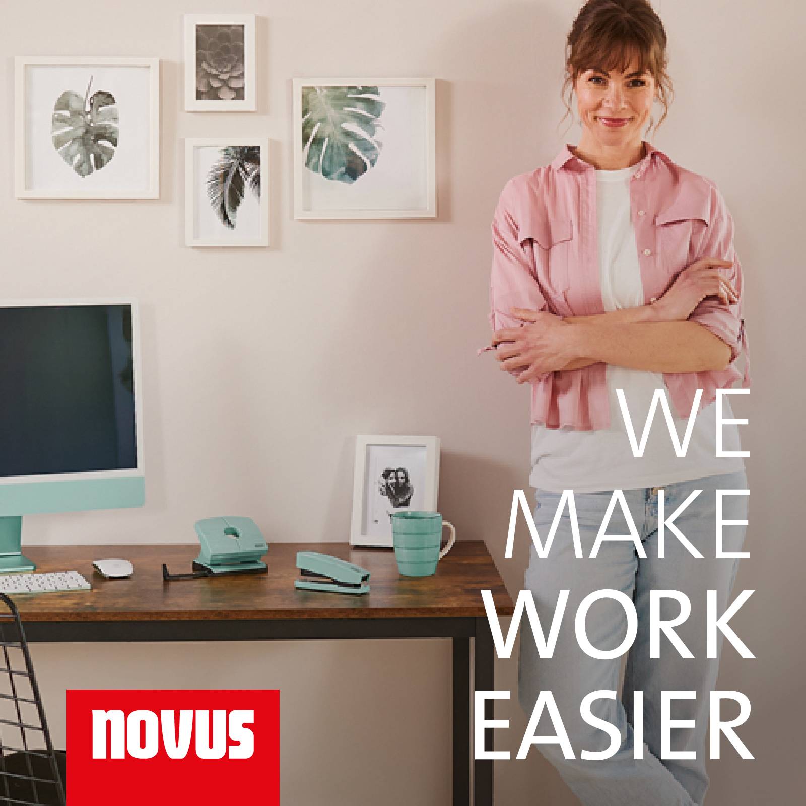 Een vrouw staat glimlachend naast een bureau met kantoorbenodigdheden, plantenfoto's aan de muur, tekst 'We make work easier'.