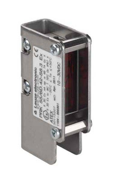 Zilveren elektronische sensor met etiket. Rechthoekige vorm met montagesleuven aan de zijkanten. Rood licht zichtbaar aan de binnenkant.