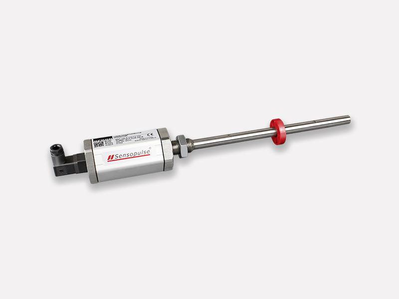 Een zilveren sensor met een metalen staaf en een rode ring in het midden op een lichte achtergrond.