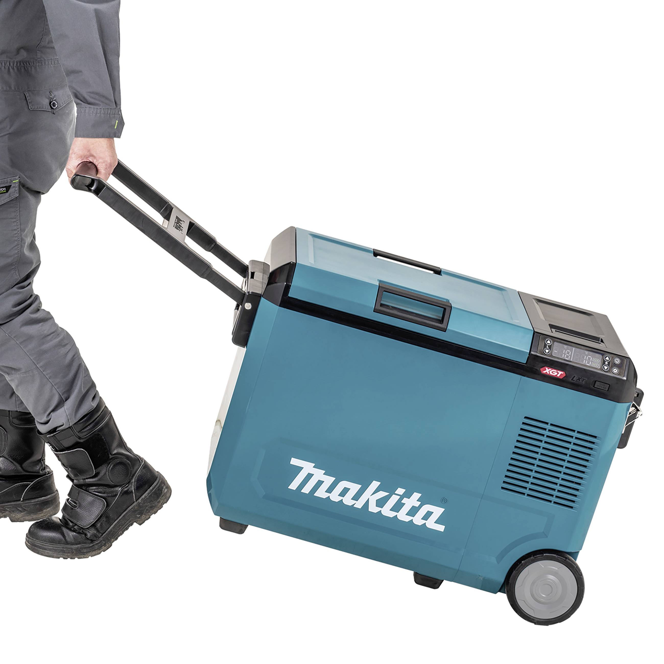 Een persoon trekt een blauwe draagbare koelkast van het merk Makita op wielen.