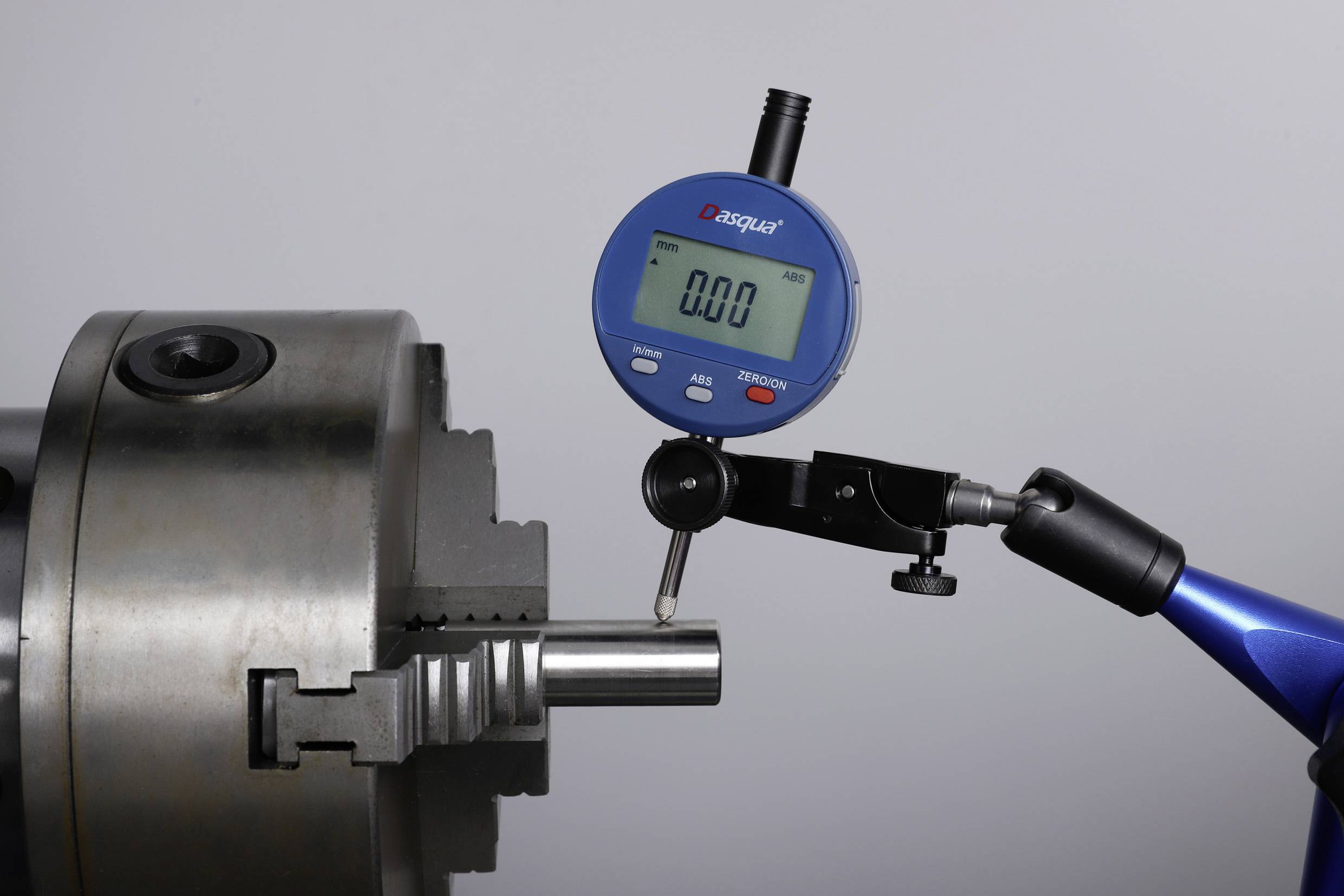 Digitaal meetinstrument meet de diameter van een metalen cilinder op een draaibank en toont '0.00 mm' op het display.