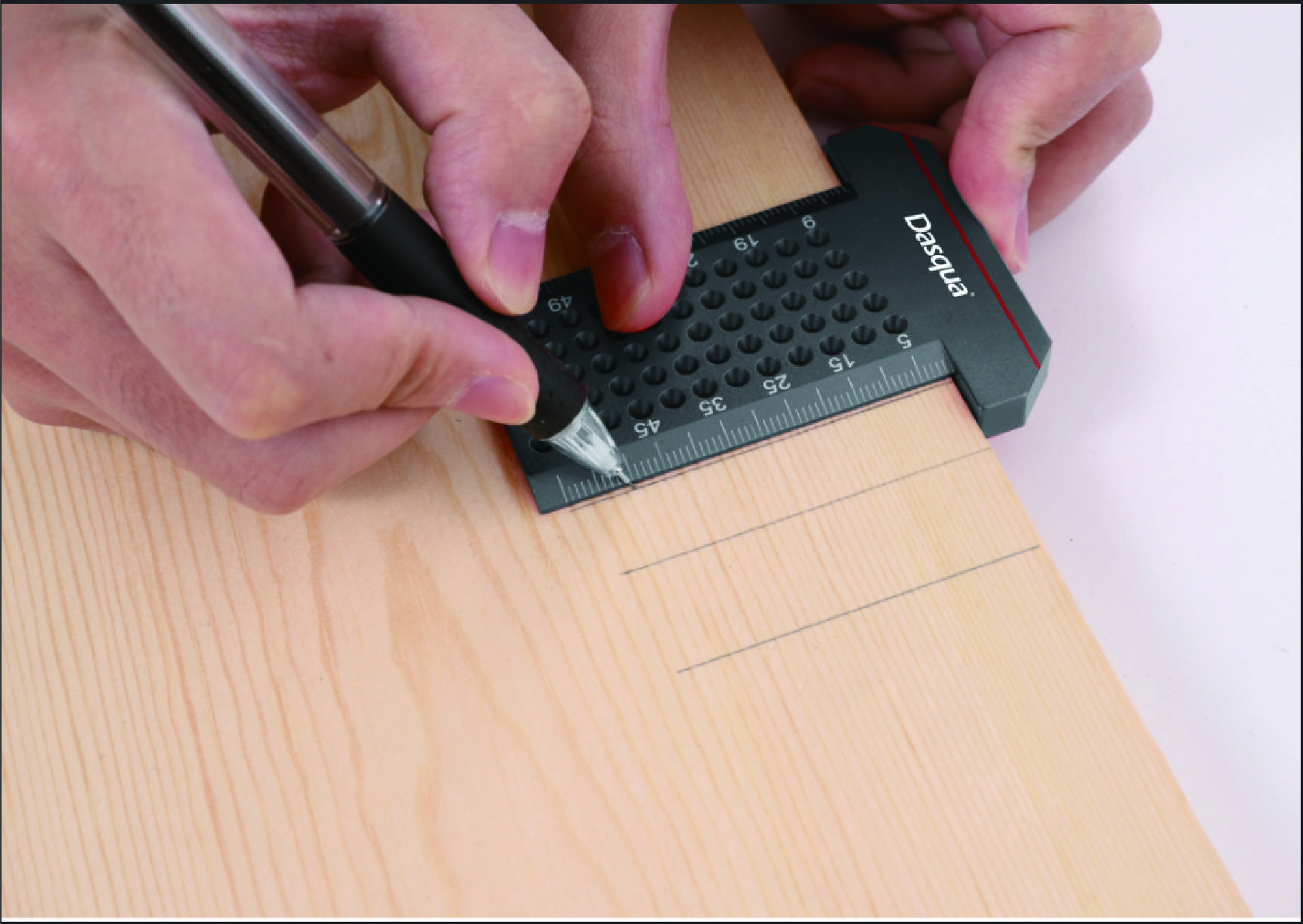 Een persoon markeert met een pen en een liniaal afmetingen op een houten plank voor een precisieknip.