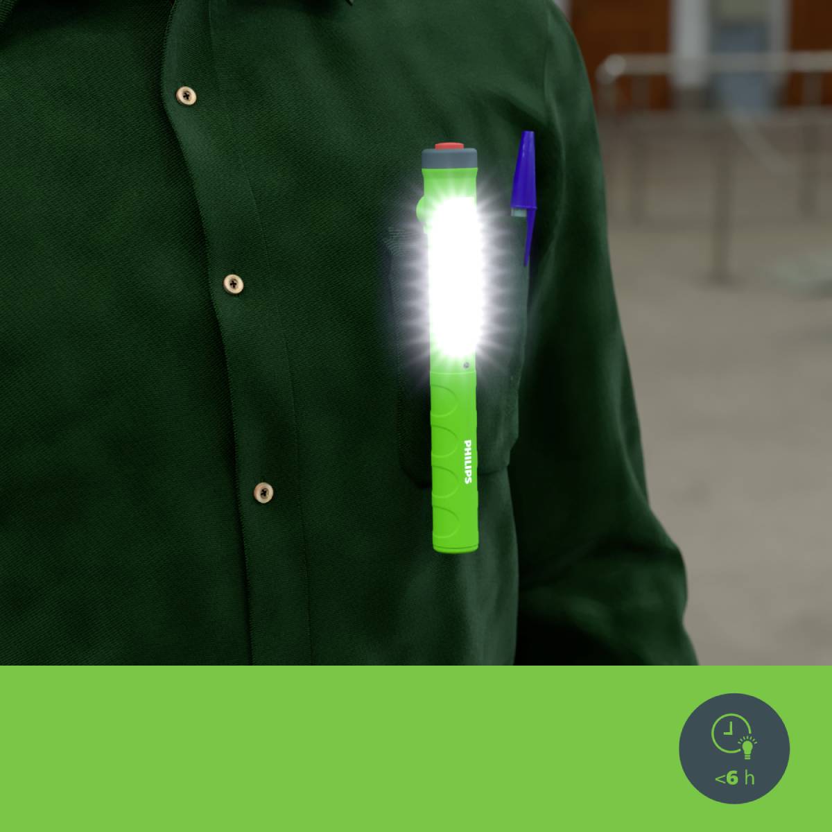 Een persoon draagt donkergroene kleding met een felgroene zaklamp bevestigd aan de borstzak.