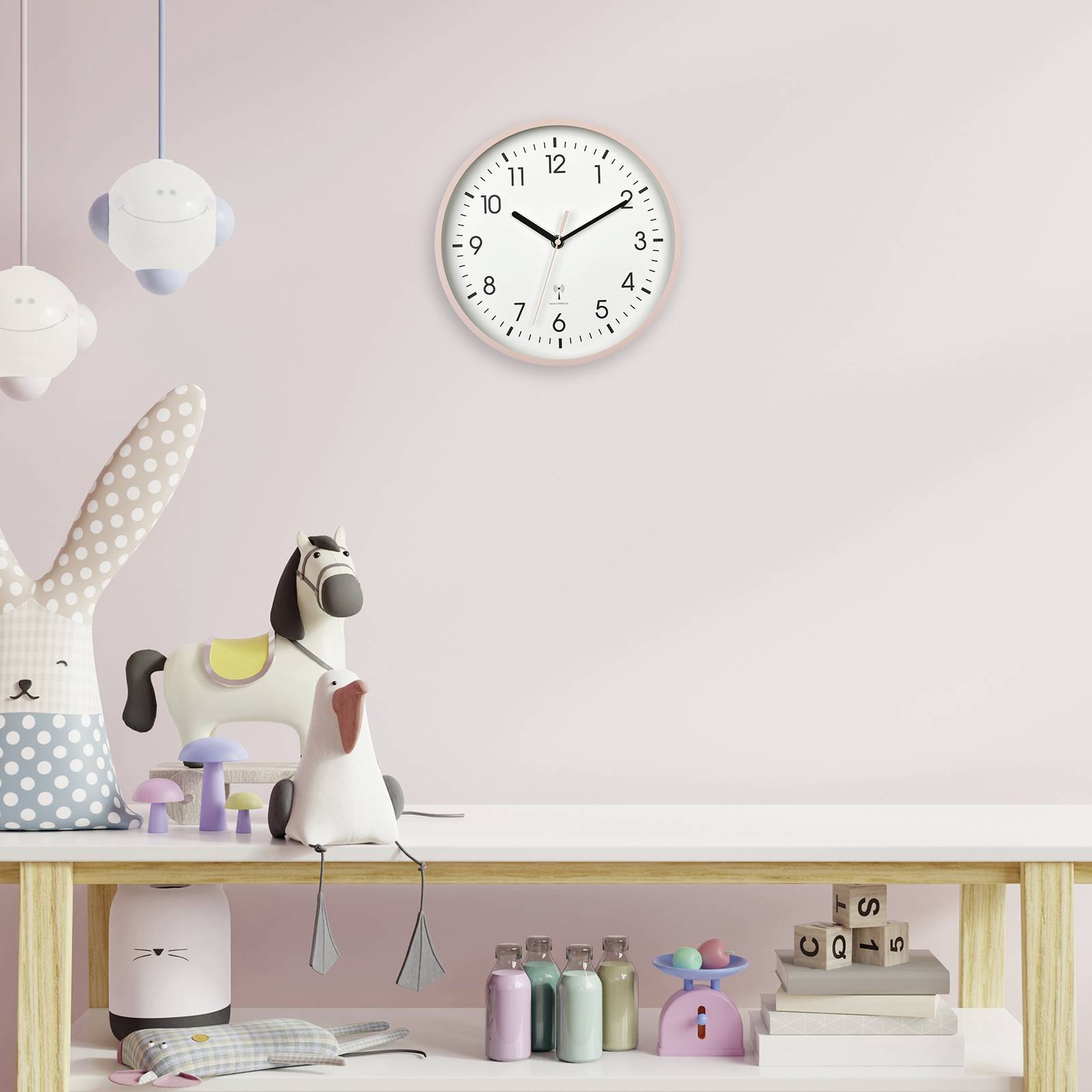 Kinderkamer met speels decor: hangende wolkenlampen, stoffen konijn, hobbelpaard en kleurrijke speelgoed op een tafel. Wandklok toont 10:09.