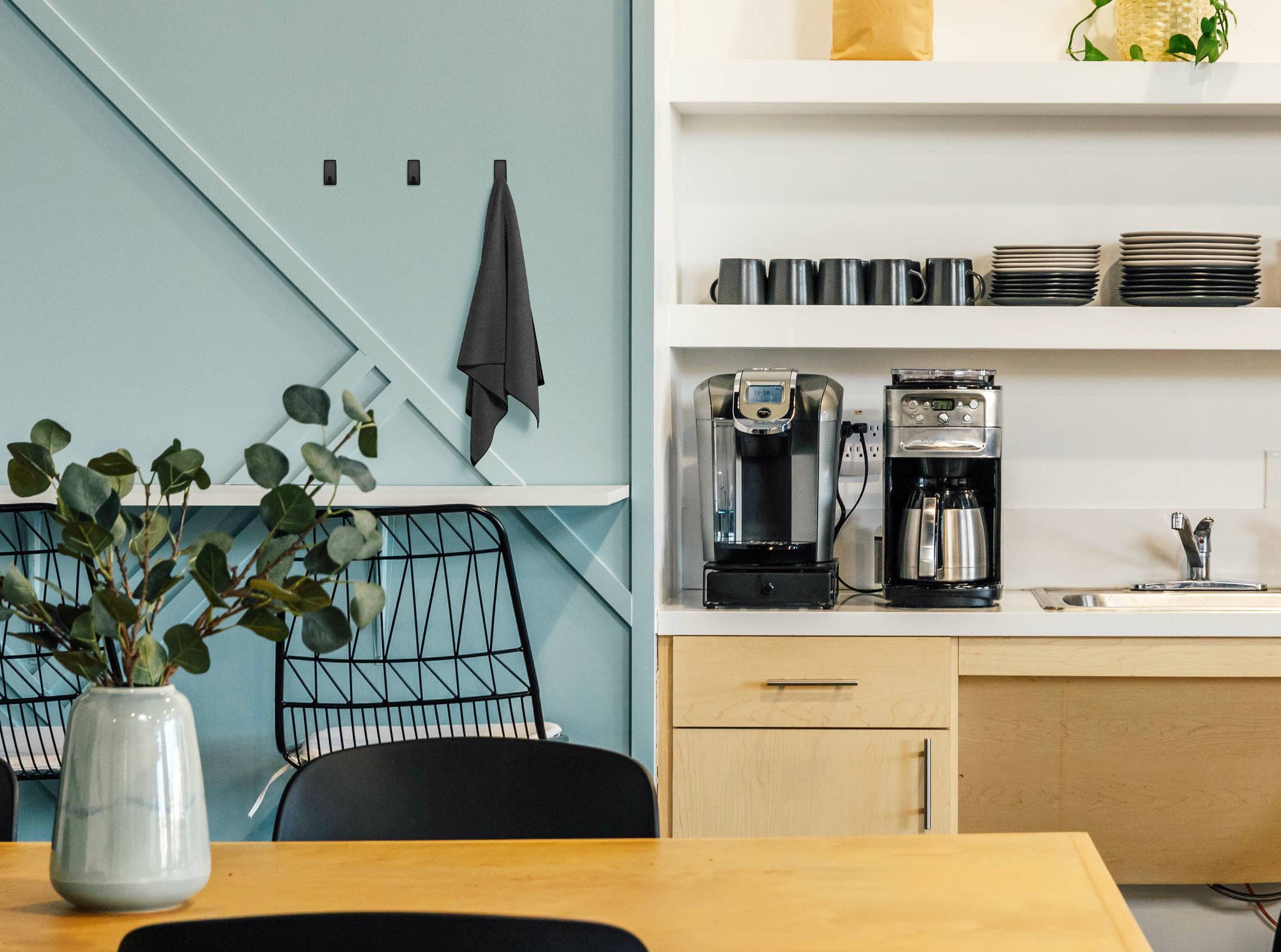 Een café met een houten toonbank. Koffiemachine en kopjesrek op de achtergrond. Groene plant in een vaas op tafel op de voorgrond.