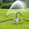 Groene waterpomp op gras, verbonden met een slang die water naar een sproeier leidt om de tuin gelijkmatig te besproeien.