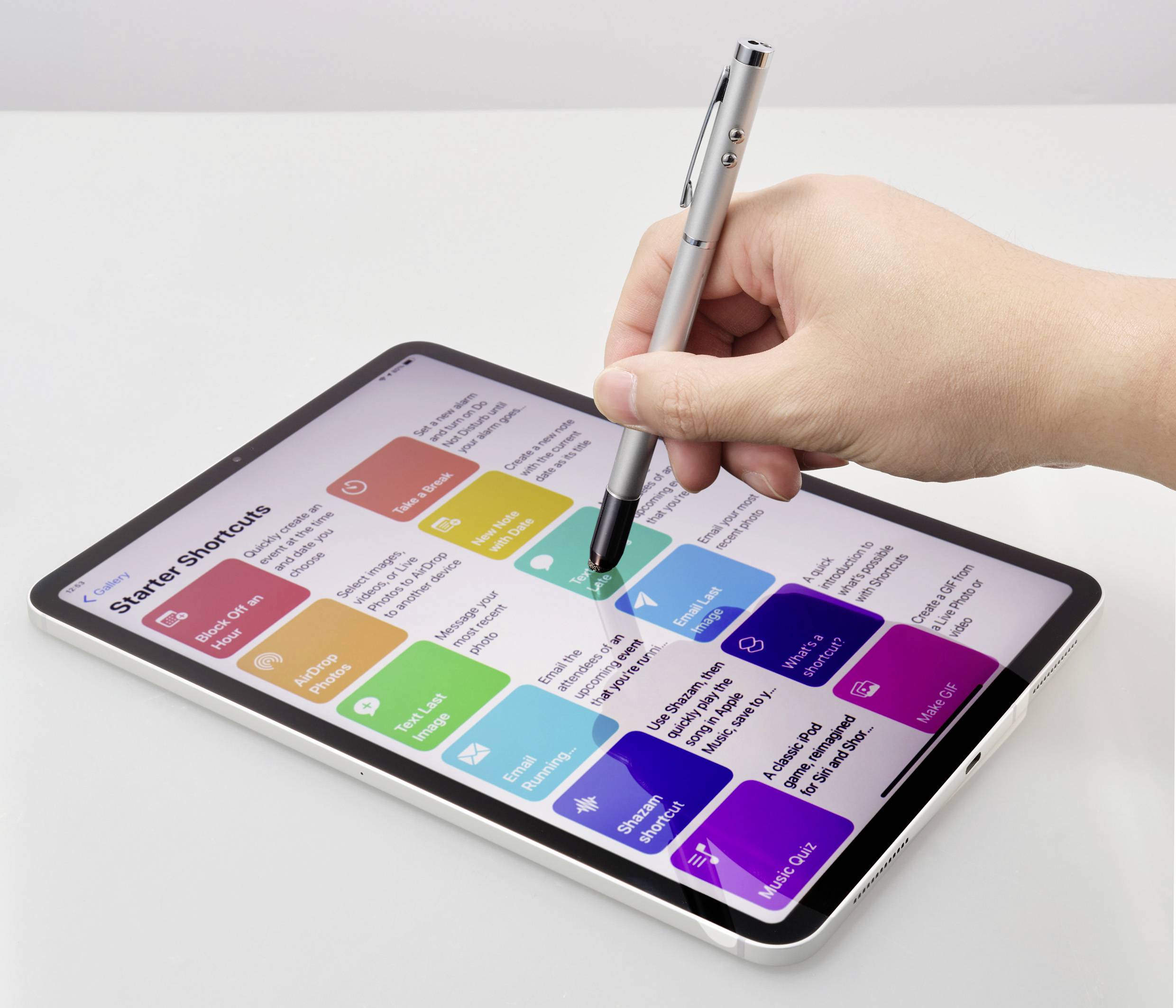 Hand bedient een tablet-pen om gekleurde app-snelkoppelingen op een scherm aan te raken. Verschillende apps zijn zichtbaar.