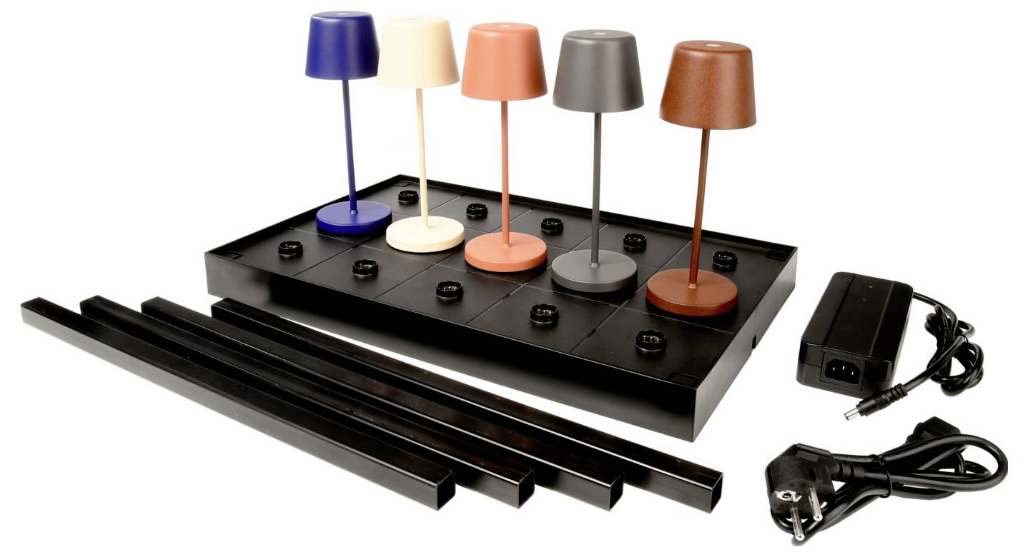 Set van vijf gekleurde bureaulampen op een zwarte displayvoet met stroomadapter en stekker, plus drie zwarte montagebalken.