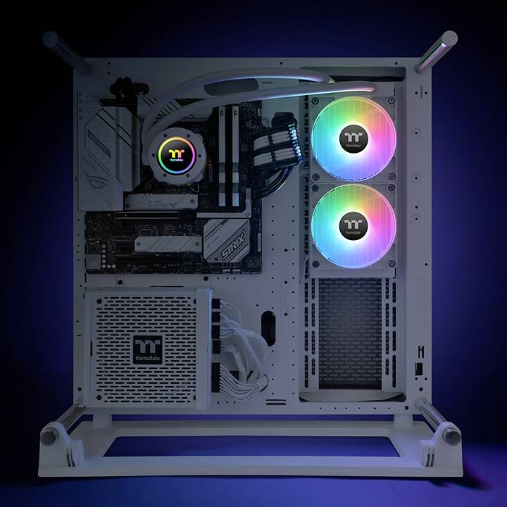 Een witte computer met zichtbare componenten en twee oplichtende RGB-ventilatoren, gemonteerd in een open frame tegen een donkere achtergrond.