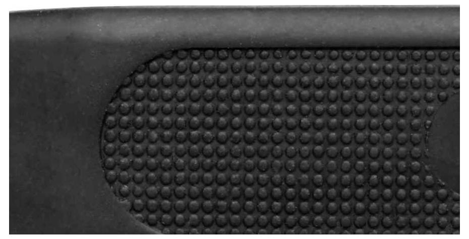 Close-up van een zwarte, gestructureerde, rubberachtige oppervlakte met ronde verhevenheden.