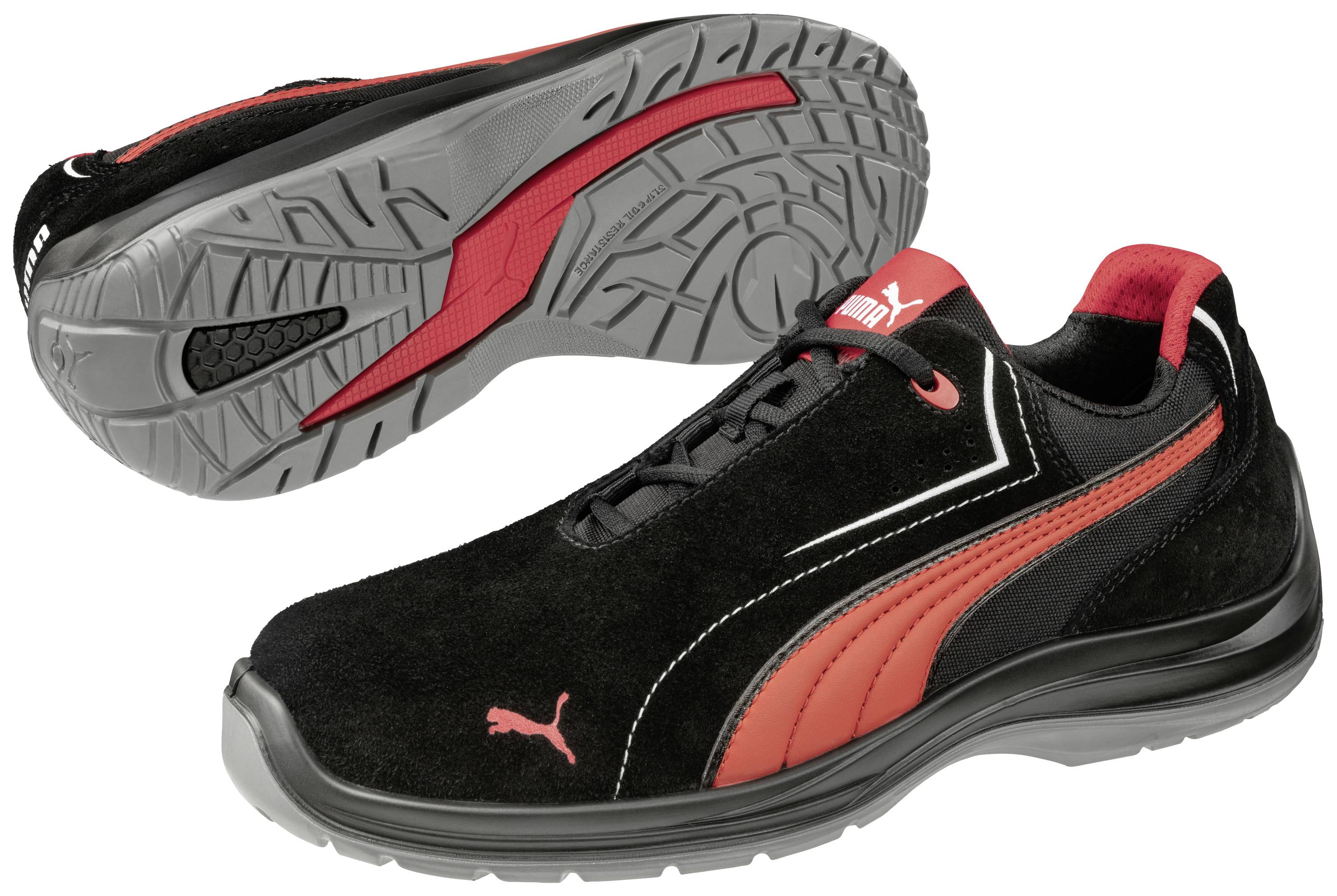 Zwarte sportschoenen met rode accenten en een grijze zool. Merklogo zichtbaar aan de zijkant en op de zool.