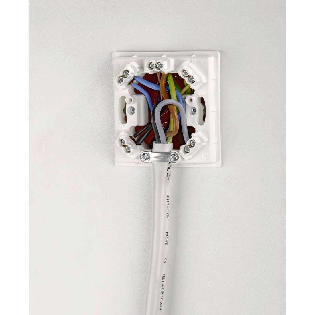 Een elektrische verdeelkast met blootliggende draden in verschillende kleuren, bevestigd aan aansluitingen.