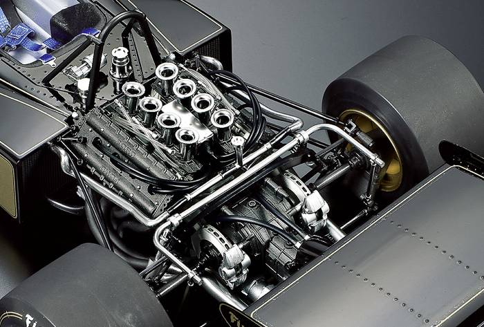 Formule 1-auto met focus op de gedetailleerde motor en ophanging. De motor is complex met zichtbare kleppen en kabels.