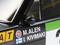 Close-up van een rallywagen met de naam 'M. Alen' en 'I. Kivimäki' op de deur, naast een Fiat-logo. De Finse vlag is zichtbaar.