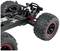 Een afstandsbediend auto-chassis met grote offroad-banden en een rode schokdemper, toont details van de vering en wielophanging.