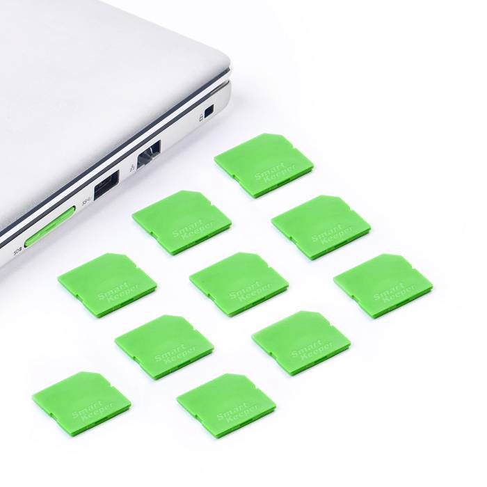 Een laptop met negen groene geheugenkaartennaast, gerangschikt in rijen. De laptop heeft meerdere aansluitingen aan de zijkant.