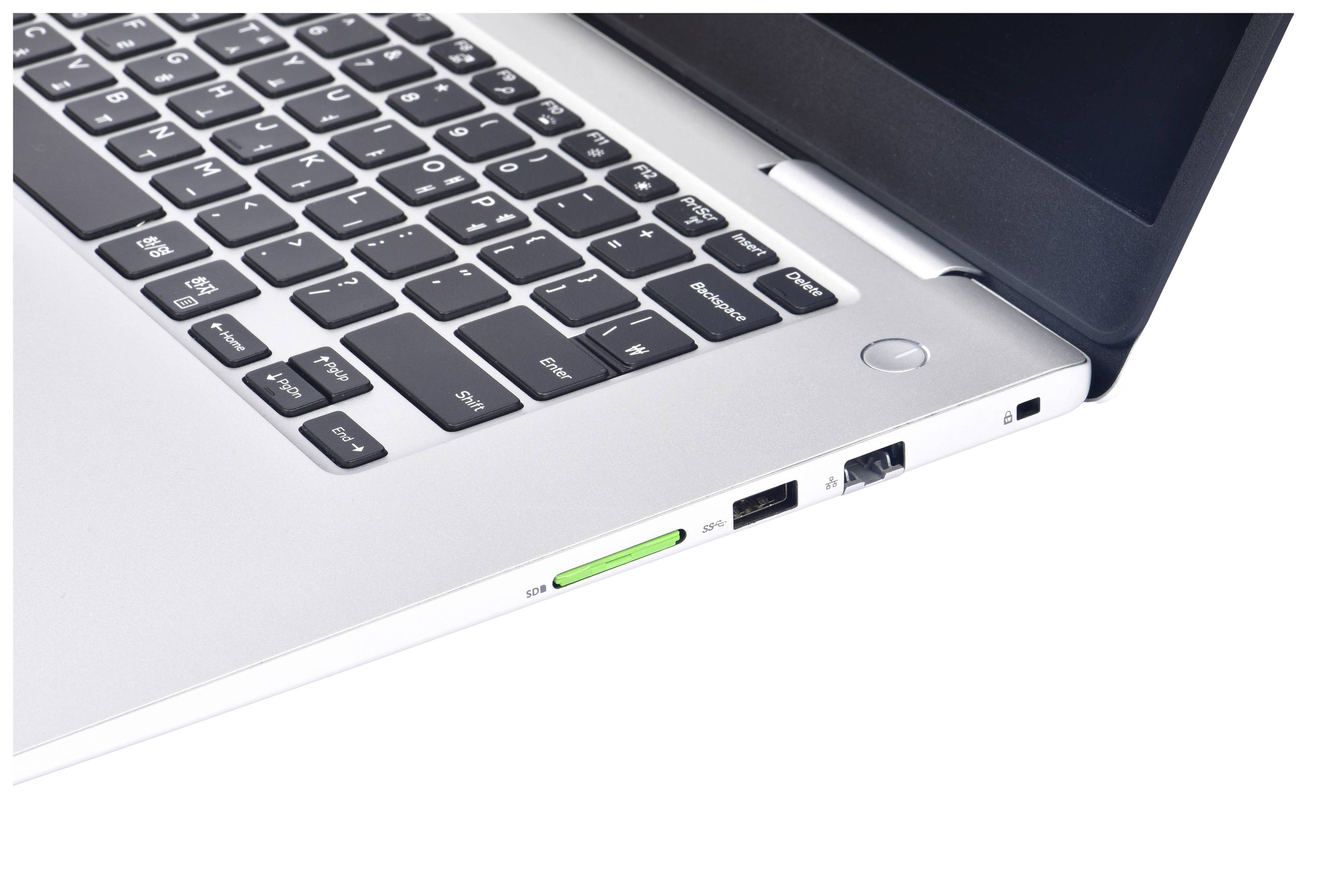 Een close-up van een zilveren laptoptoetsenbord met een USB-stick aangesloten aan de linkerkant.