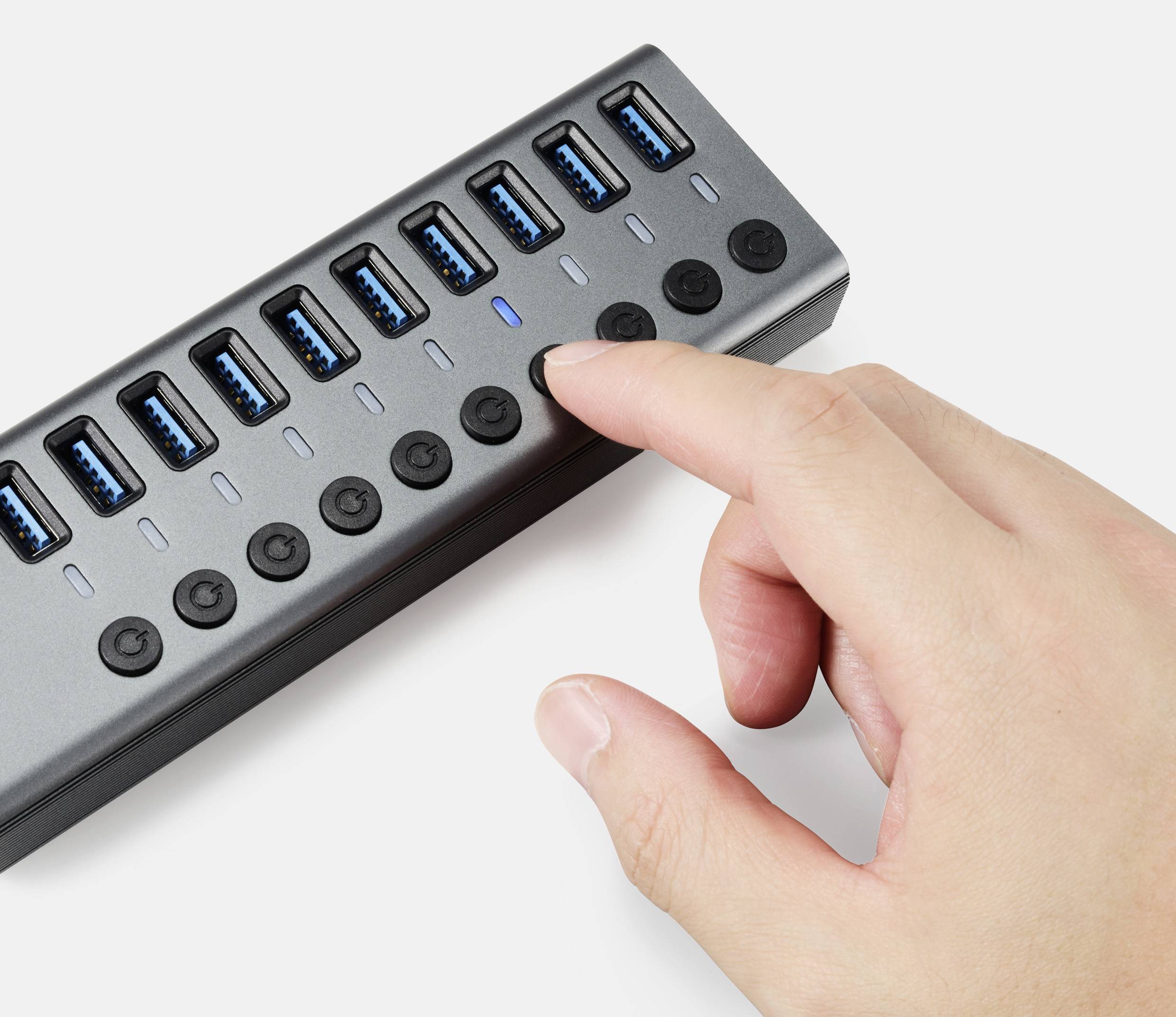 'Een hand schakelt een toets in op een USB-hub met meerdere aansluitingen.'