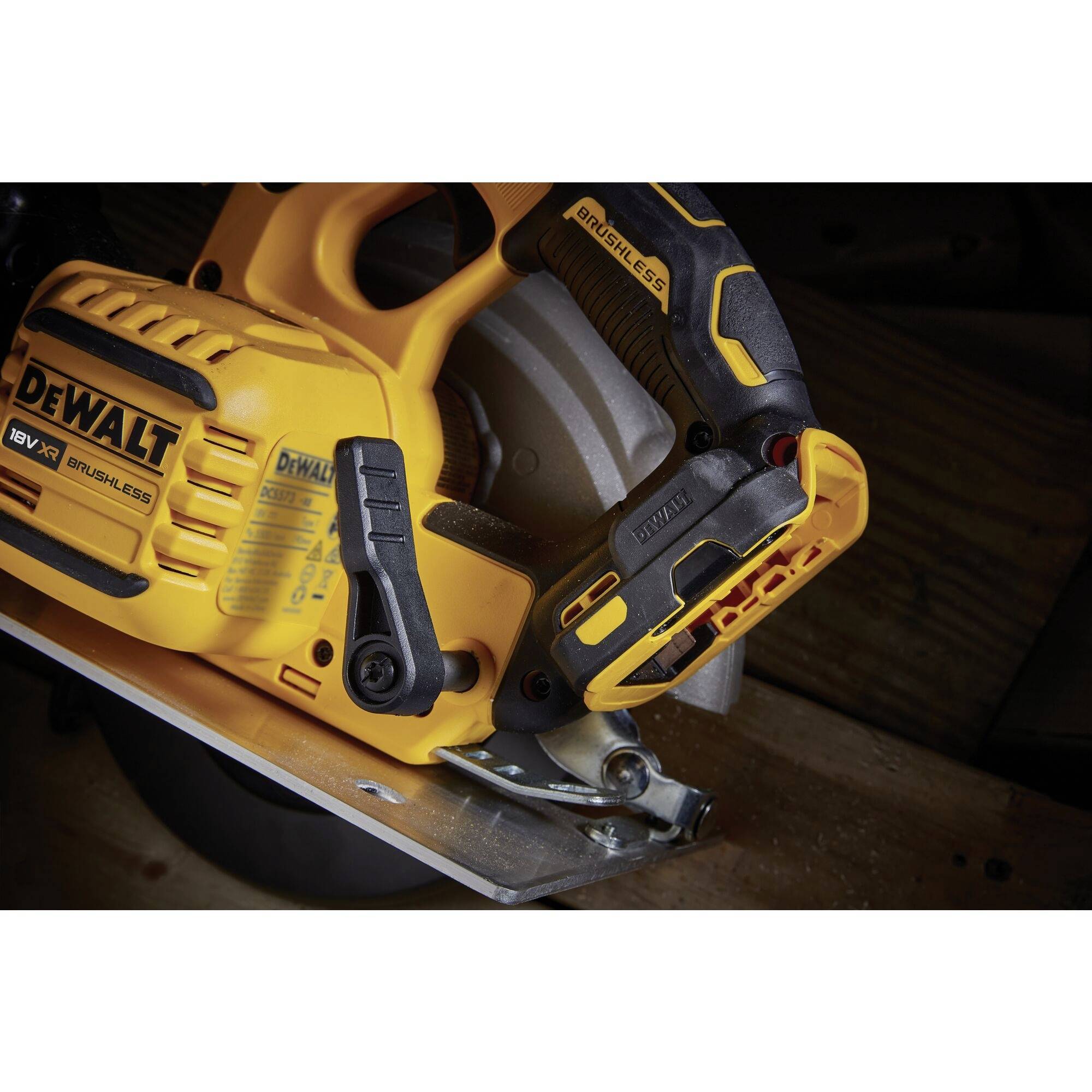 Accubetriebene gele DEWALT-cirkelzaag op een houten tafel in close-up, toont de handgreep en het zaagblad zonder dat deze in werking is.