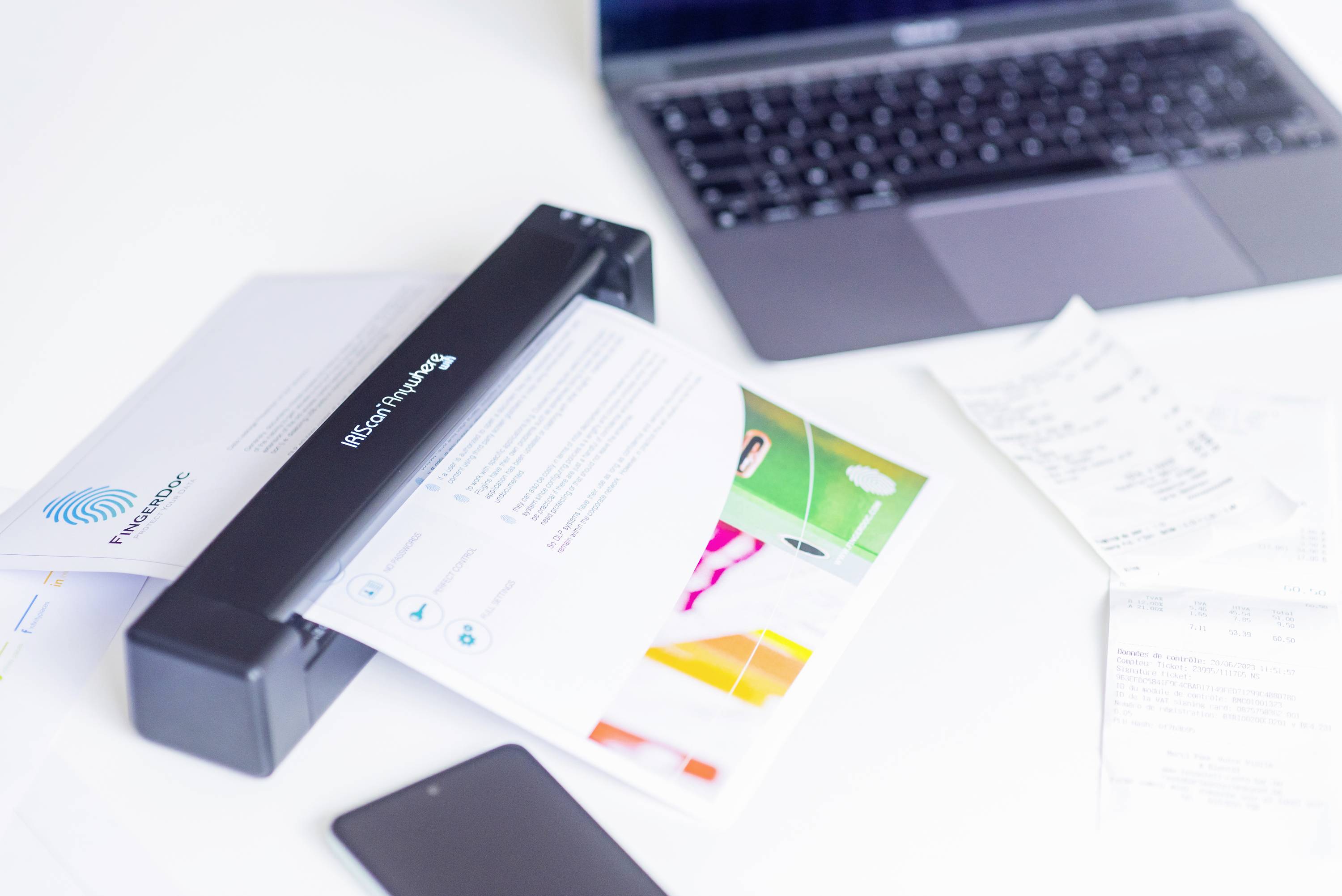 'Scanner op bureau scant een document, naast een laptop en bewijsstukken. Kantoorwerkplek met moderne technologie.'