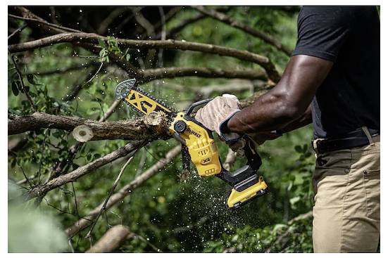 'Een persoon die een gele kettingzaag gebruikt om een boomtak door te zagen in een buitenomgeving, omgeven door groen gebladerte.'