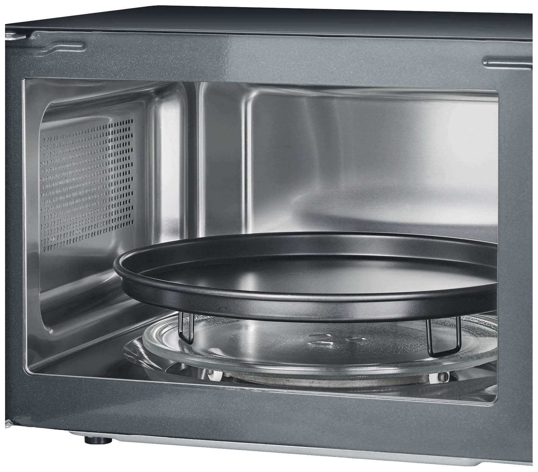 Een open magnetron met een draaiplateau aan de binnenkant, klaar voor gebruik. De binnenkant is van roestvrij staal.