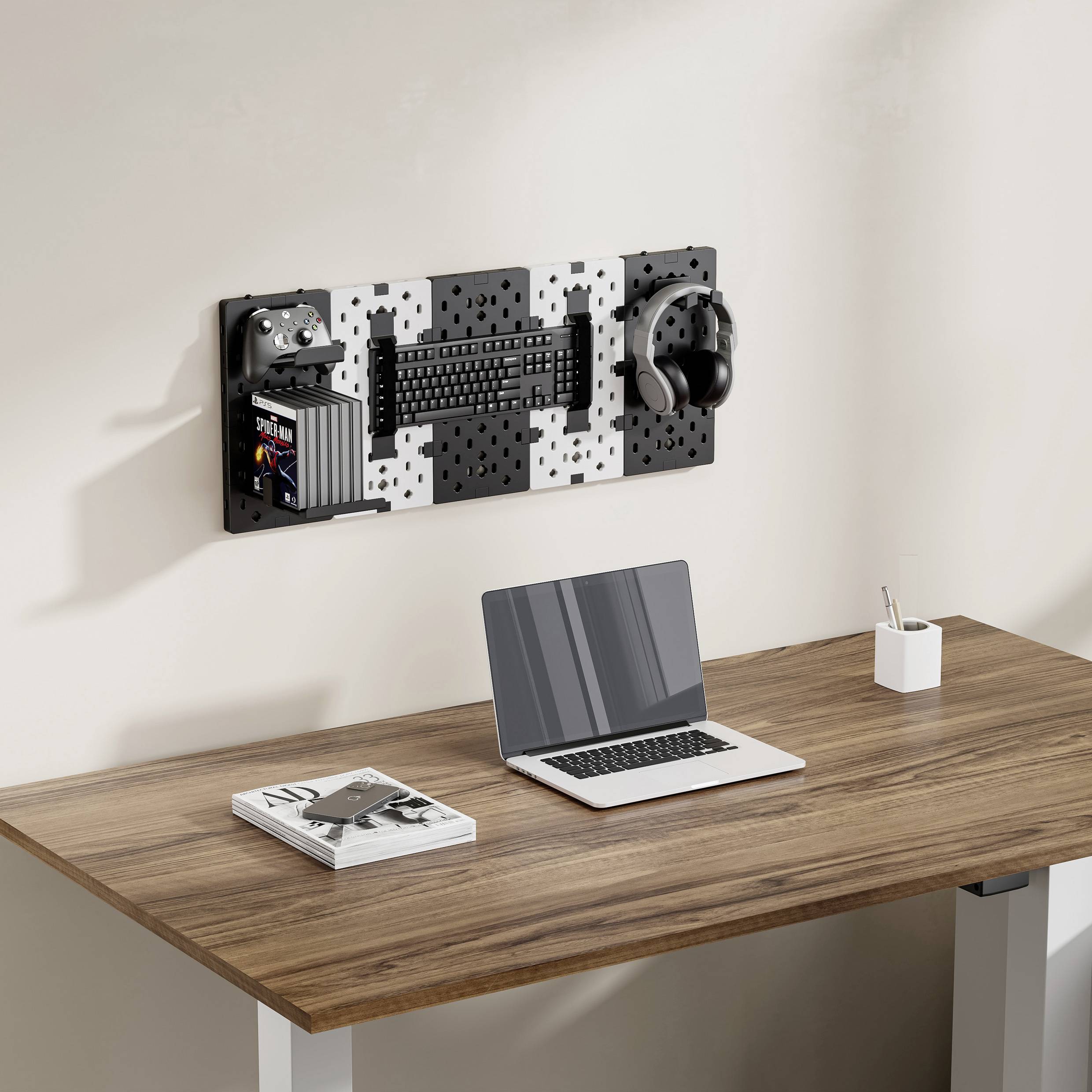 Een moderne bureautafel met een laptop, een kopje koffie en een boek. Aan de muur hangt een organizer met een gamingcontroller, toetsenbord en koptelefoon.