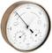 Rond barometer met koperkleurige rand. Toont luchtdruk in hPa, weerstendens, luchtvochtigheid en temperatuur.
