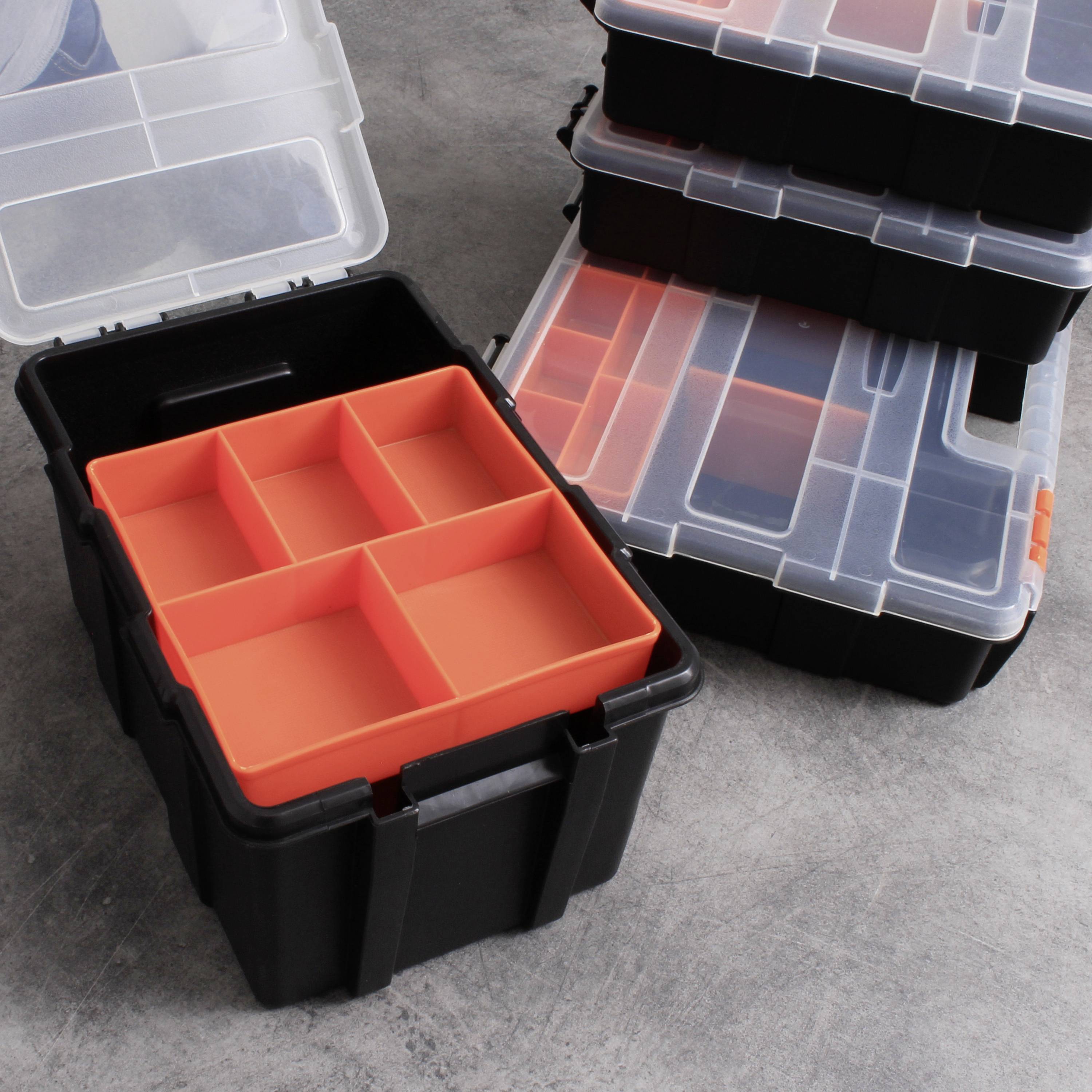 Geopende zwarte opbergdoos met uitneembare rode vakken, naast gestapelde gesloten dozen. Ideaal voor gereedschapsorganisatie.