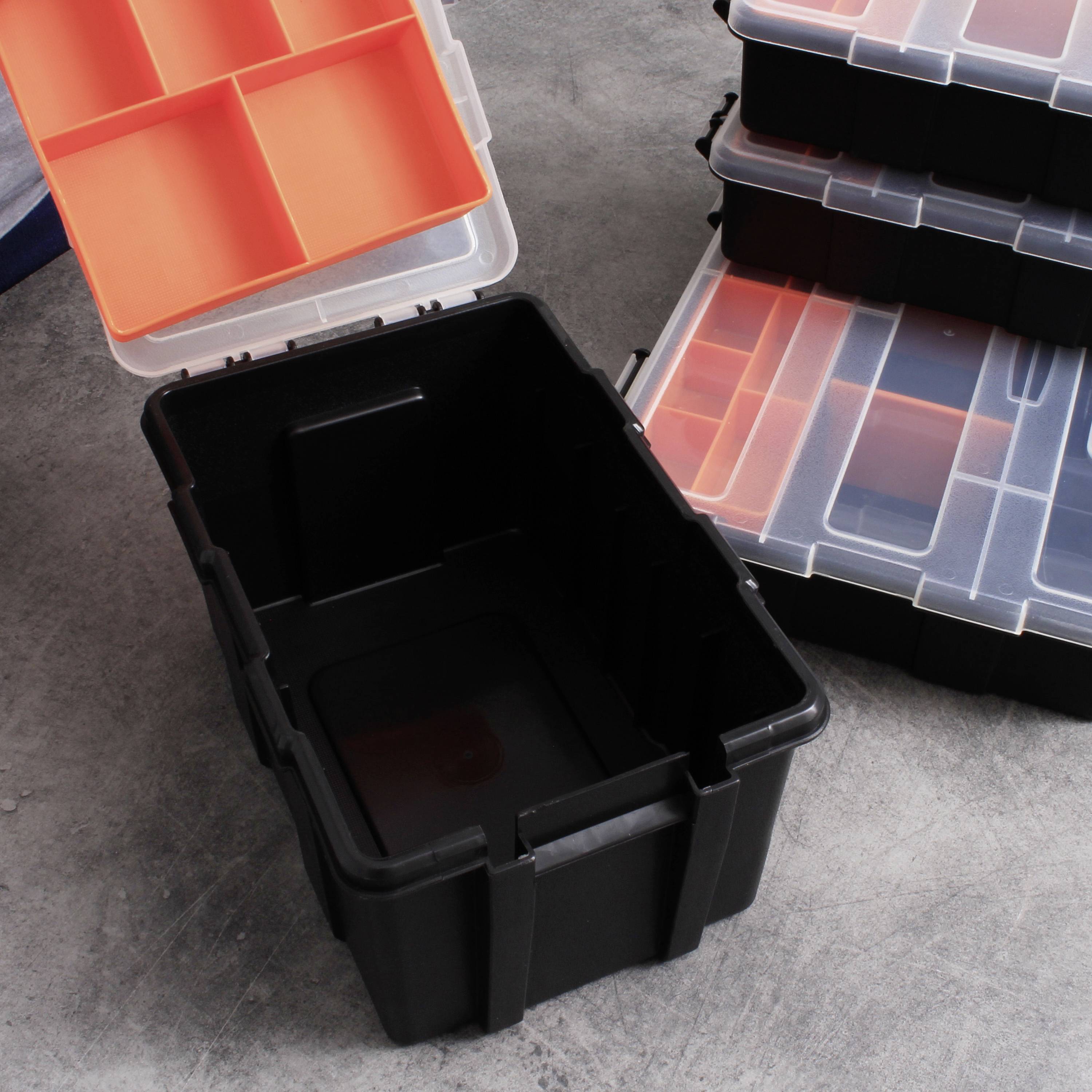 Zwarte opslagdozen met afneembare deksels en oranje scheidingsvakken, gestapeld op een betonnen vloer.