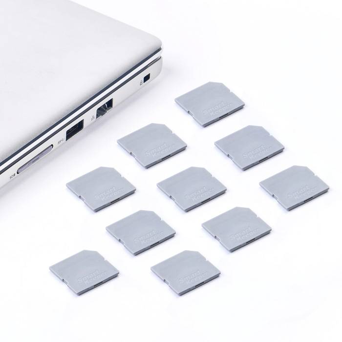Een laptop naast tien SD-kaarten, uitgelijnd op een wit oppervlak. Ze symboliseren digitale opslag en uitbreiding.