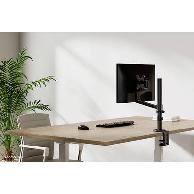Een moderne bureau met een gemonteerd scherm, een toetsenbord en een muis. Naast de tafel staat een grote groene plant.