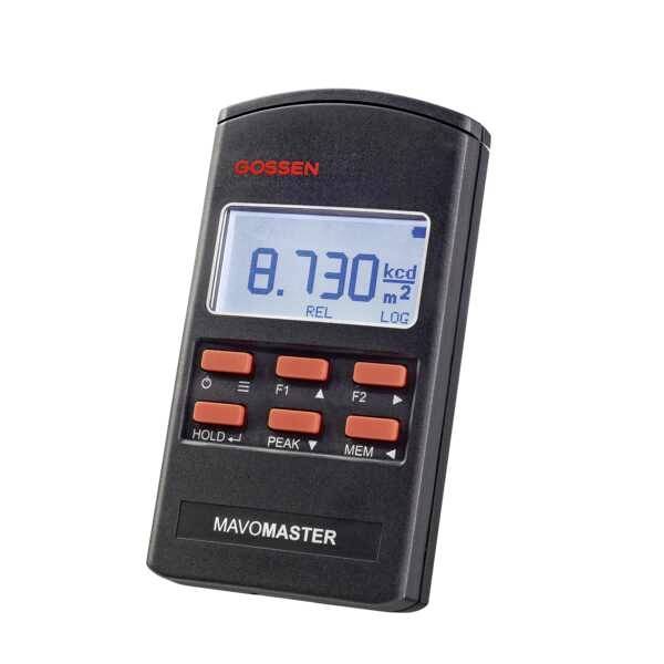 Handmeetapparaat met digitaal display toont '8.730 kcd/m²'. Rode toetsen gemarkeerd met 'F1', 'F2', 'HOLD', 'PEAK', 'MEM'. Bovenaan staat 'GOSSEN'.