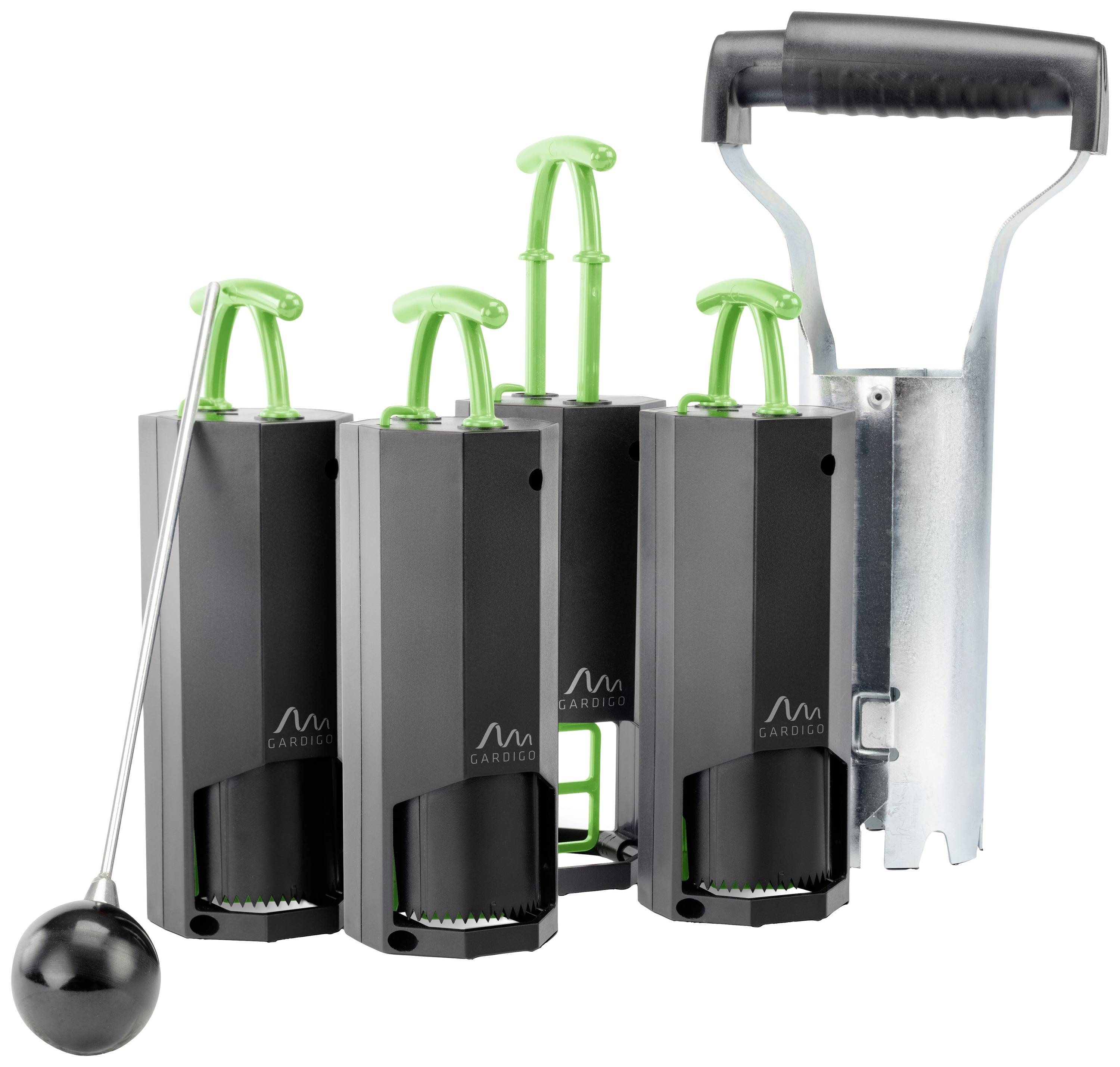 Drie zwarte apparaten met groene hendels staan naast elkaar, rechts is een metalen houder met een zwarte handgreep. Links een zwarte bal aan een stang.