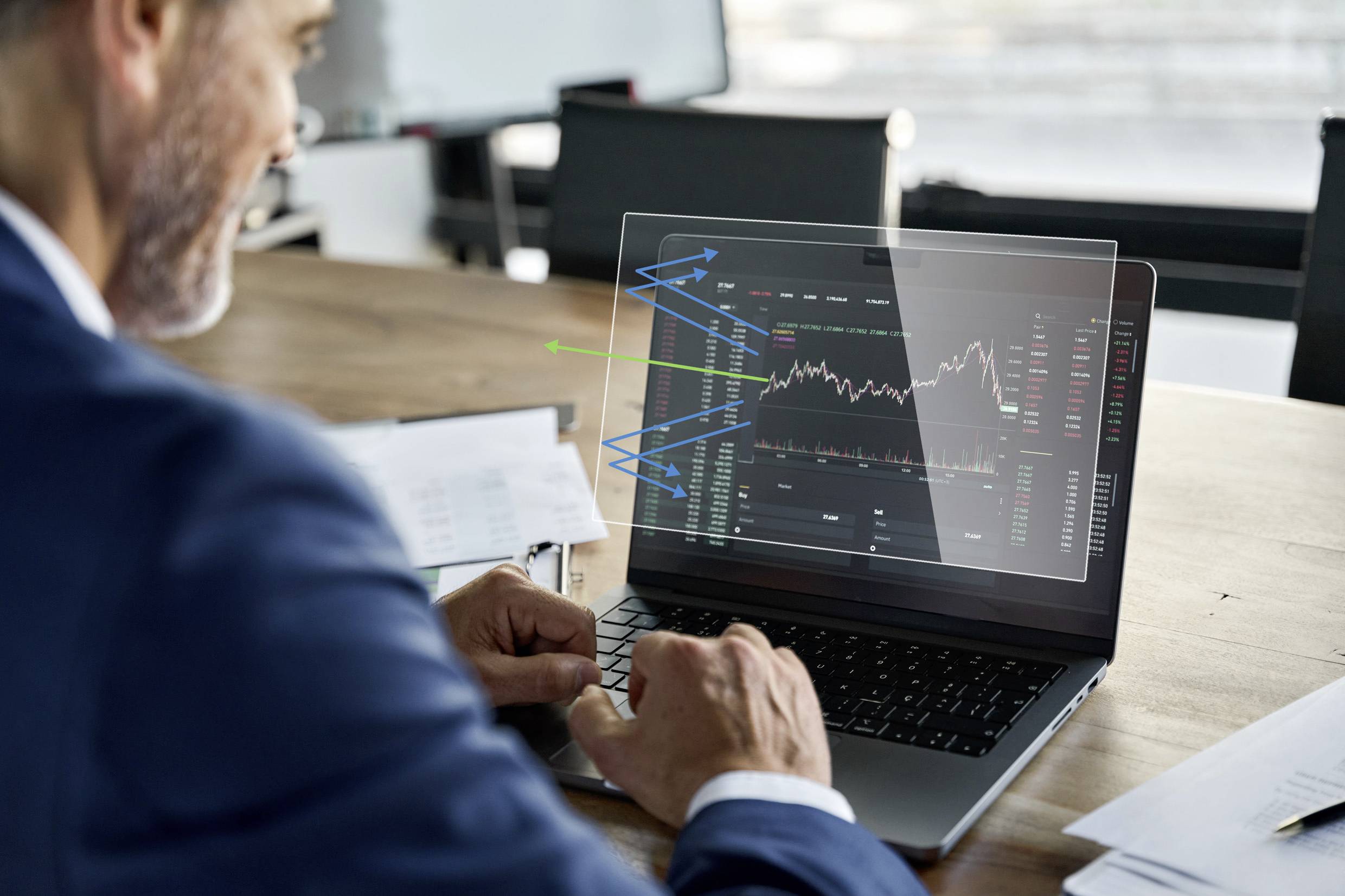 Een man analyseert financiële gegevens op een laptop die op een tafel ligt. Het scherm toont een aandelenkoersgrafiek met stijgings- en dalingpercentages.