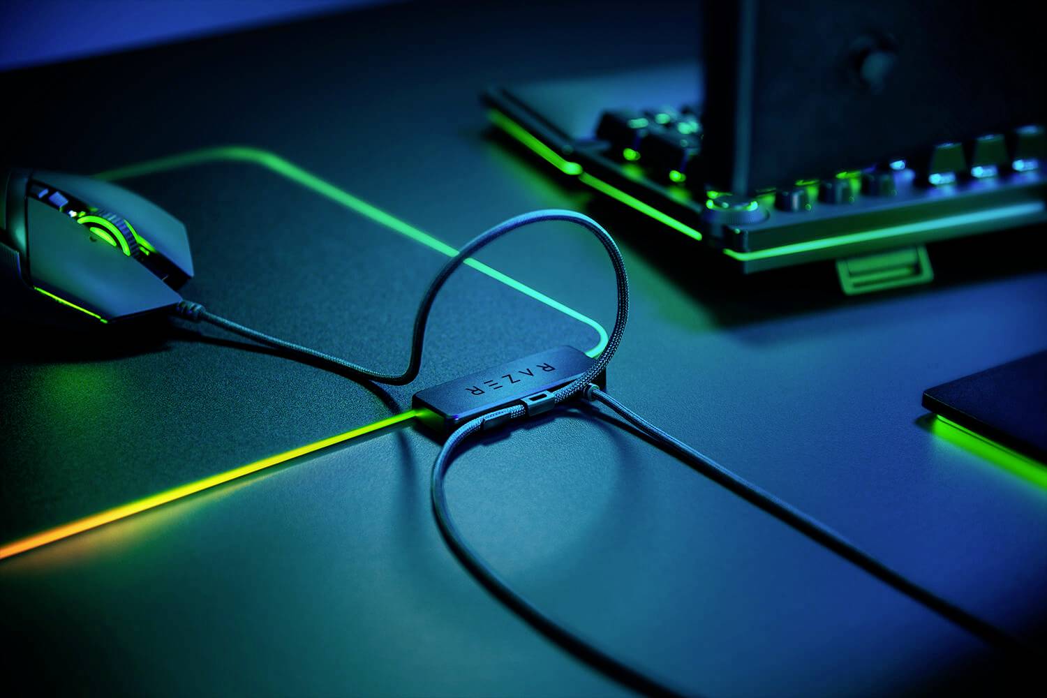 Computertafel met verlichte gaming-muis, kabelbeheersysteem en toetsenbord. Groene lichteffecten zorgen voor een sfeervolle ambiance.