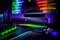 Gaming-setup met verlichte monitor, soundbar en toetsenbord in RGB-kleuren. Neonkleuren creëren een futuristische sfeer.