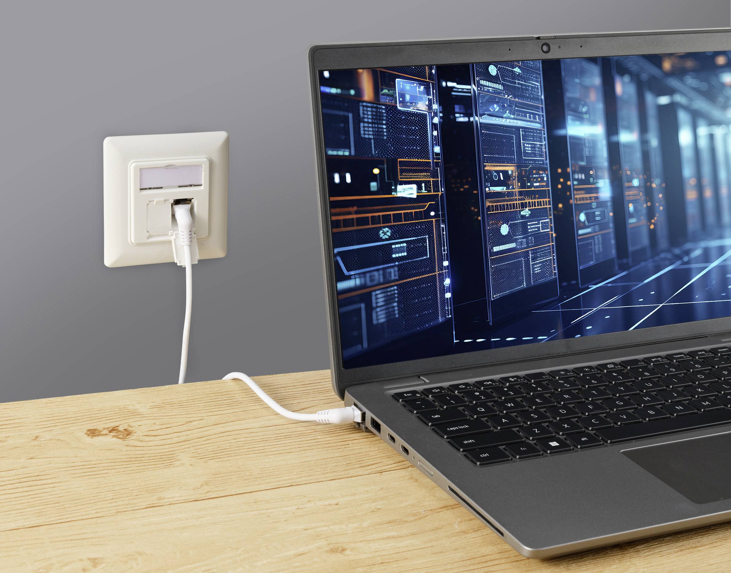 Een laptop op een houten tafel is via een netwerkkabel aangesloten op een stopcontact. Het scherm toont digitale netwerkgrafieken.