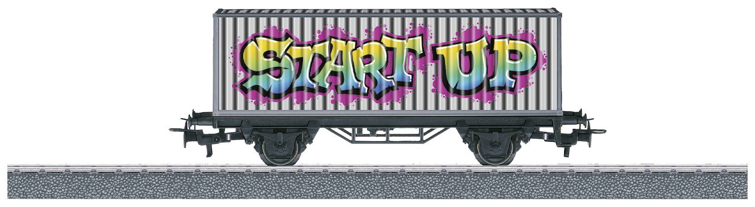 Vrachtwagen met graffiti van het woord 'START UP' in felle kleuren aan de zijkant, geparkeerd op een spoorsectie.