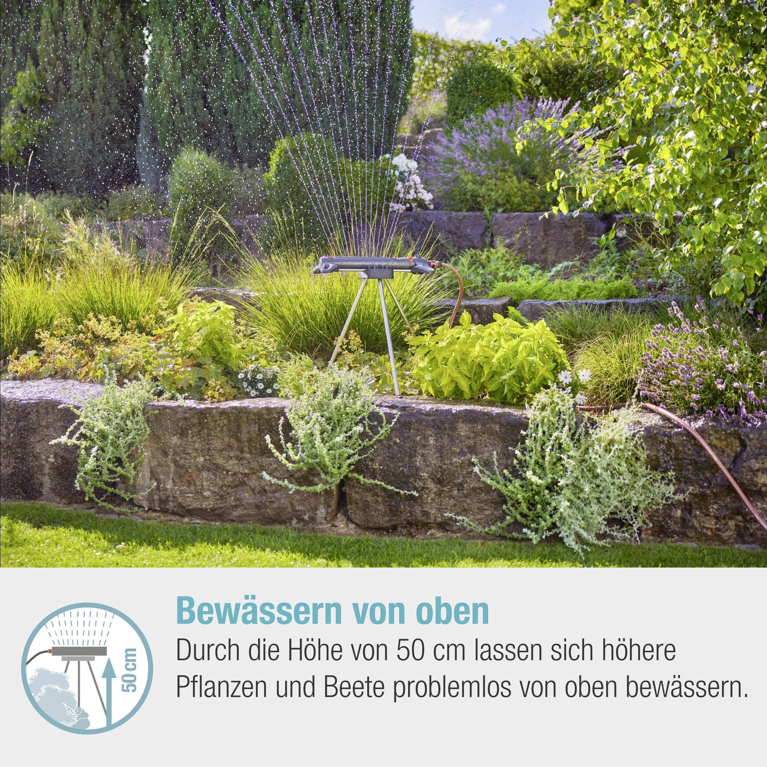 Een sproeier besproeit een tuin met planten op verschillende hoogtes. Tekst: "Door de hoogte van 50 cm kunnen hogere planten en borders gemakkelijk van bovenaf worden besproeid."