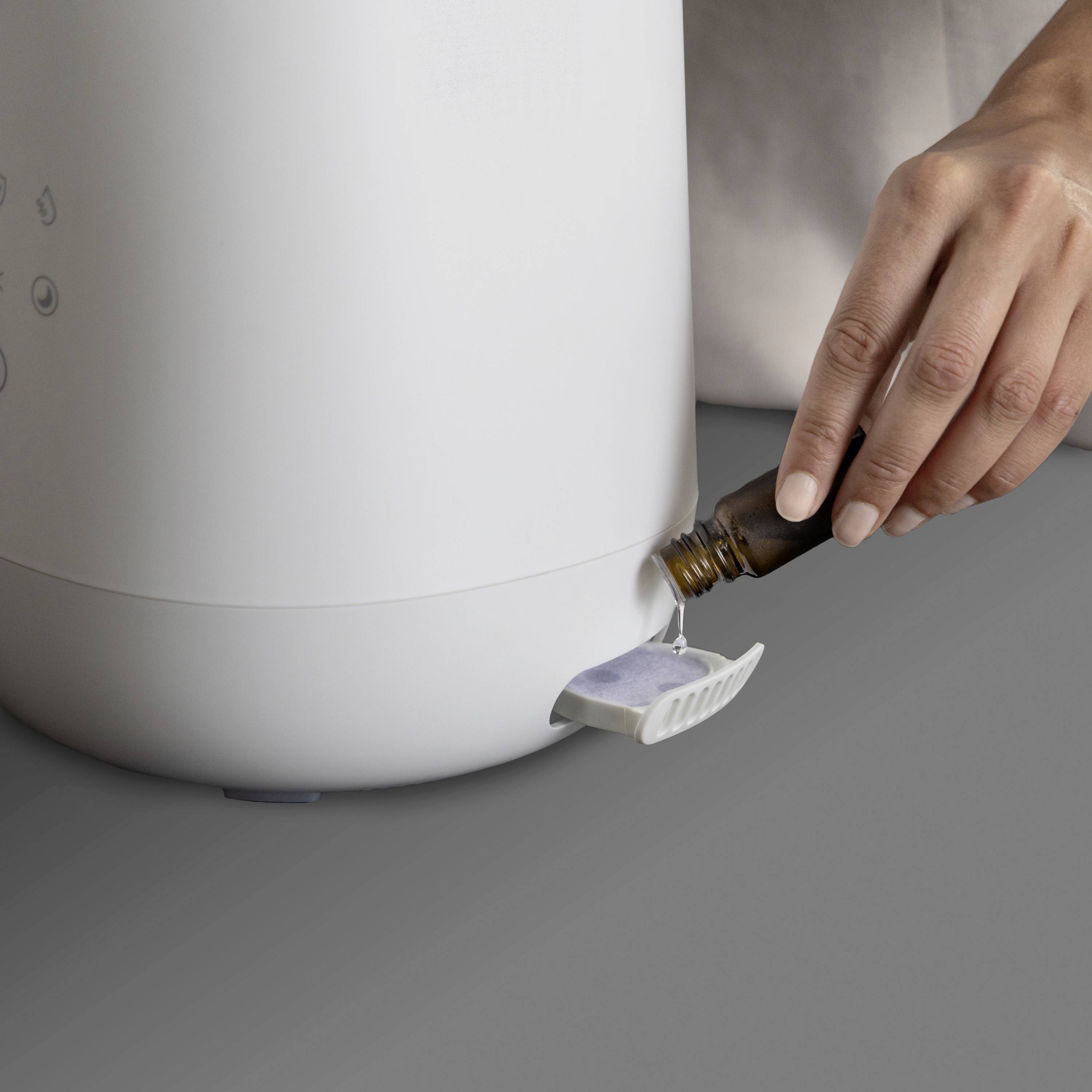 Een persoon draait de aftapkraan van een grote, witte watercontainer open om de vloeistof af te laten.