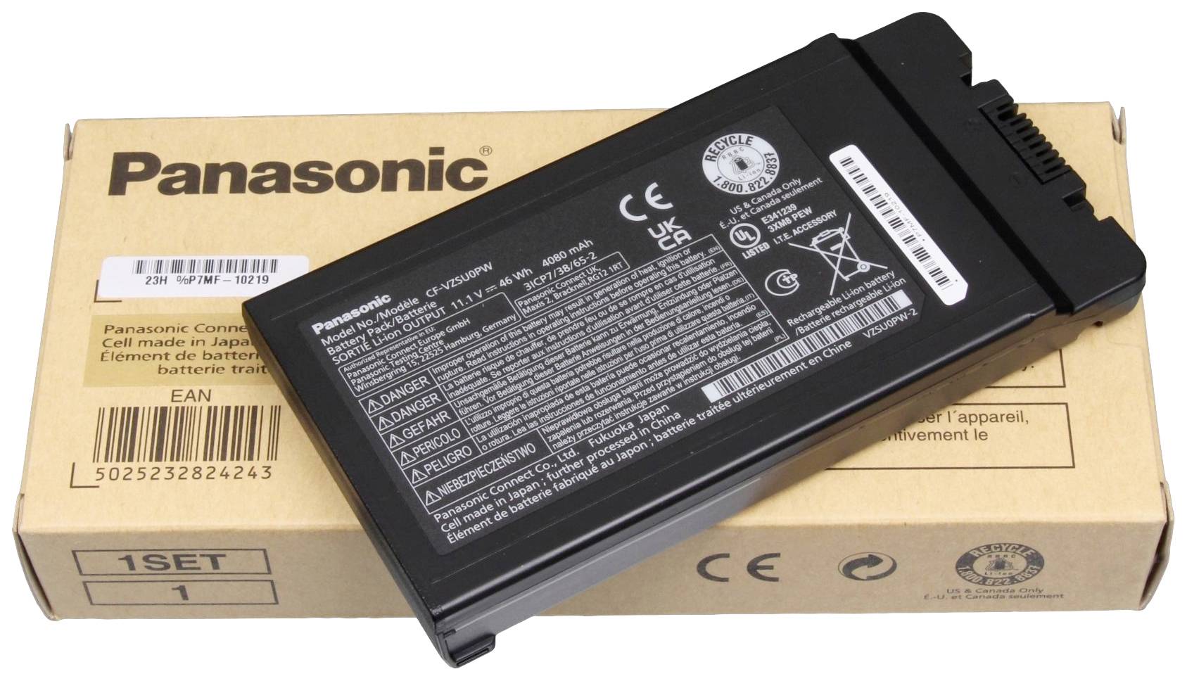 Een zwarte Panasonic-batterij ligt op een bruine kartonnen doos met Panasonic-logo en barcodes.