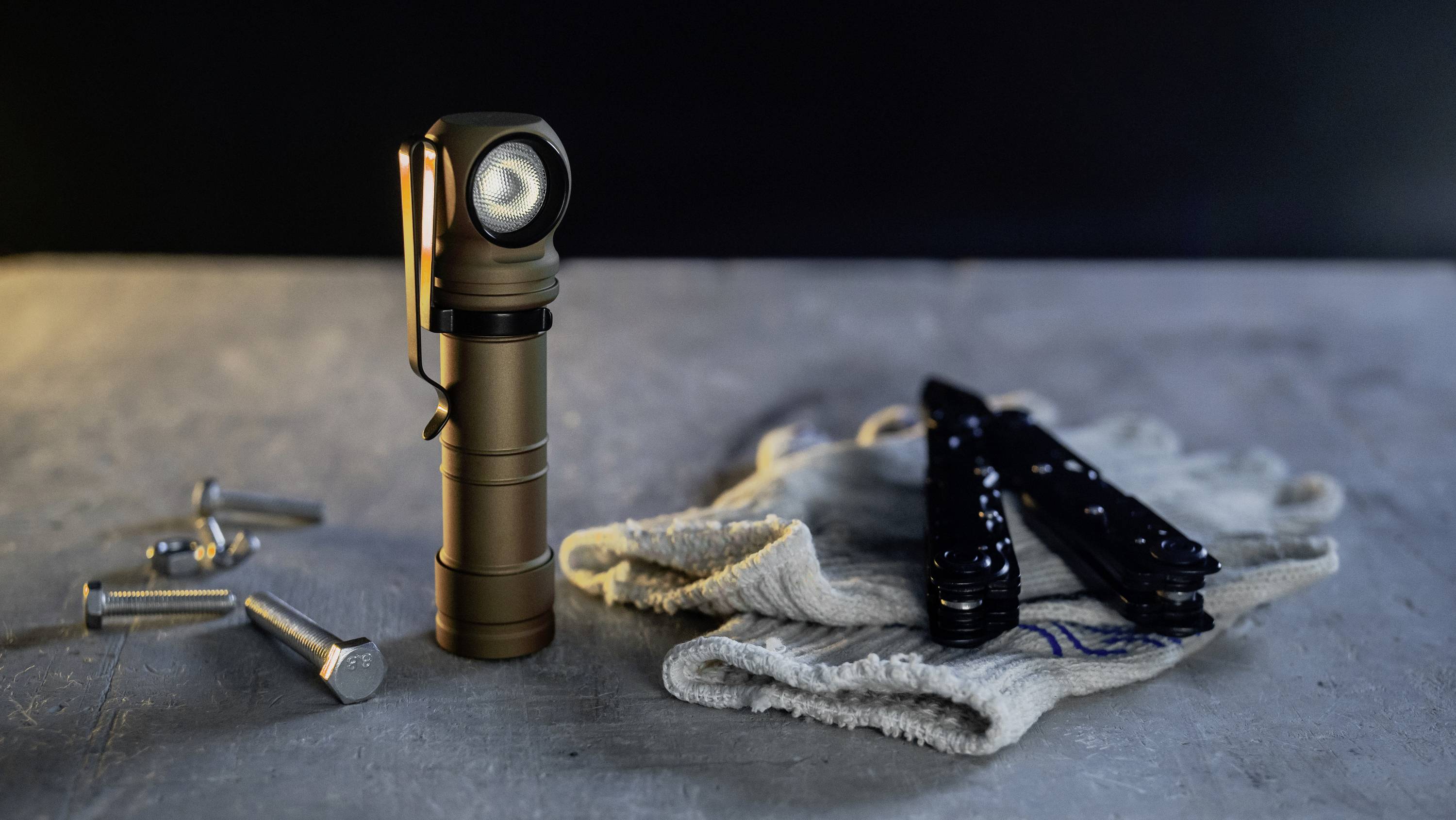 Een zaklamp staat op een tafel naast een handdoek en gereedschappen.