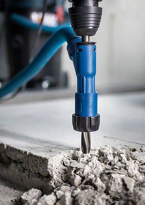 Een elektrische breekhamer breekt de betonvloer open om renovatiewerkzaamheden mogelijk te maken.