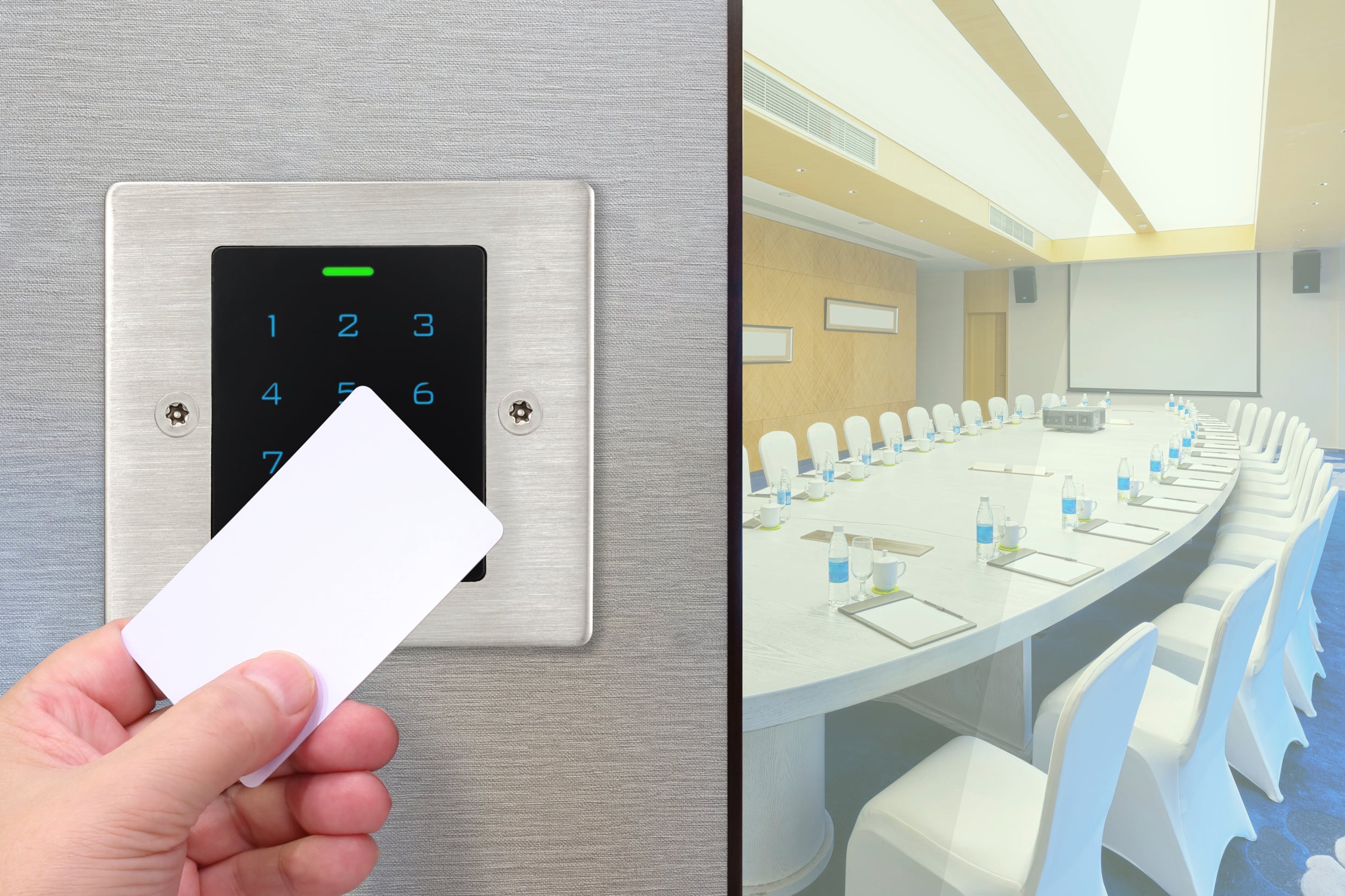 Een persoon houdt een kaart voor een elektronisch deurslot bij een lege vergaderzaal, wat toegangscontrole symboliseert.