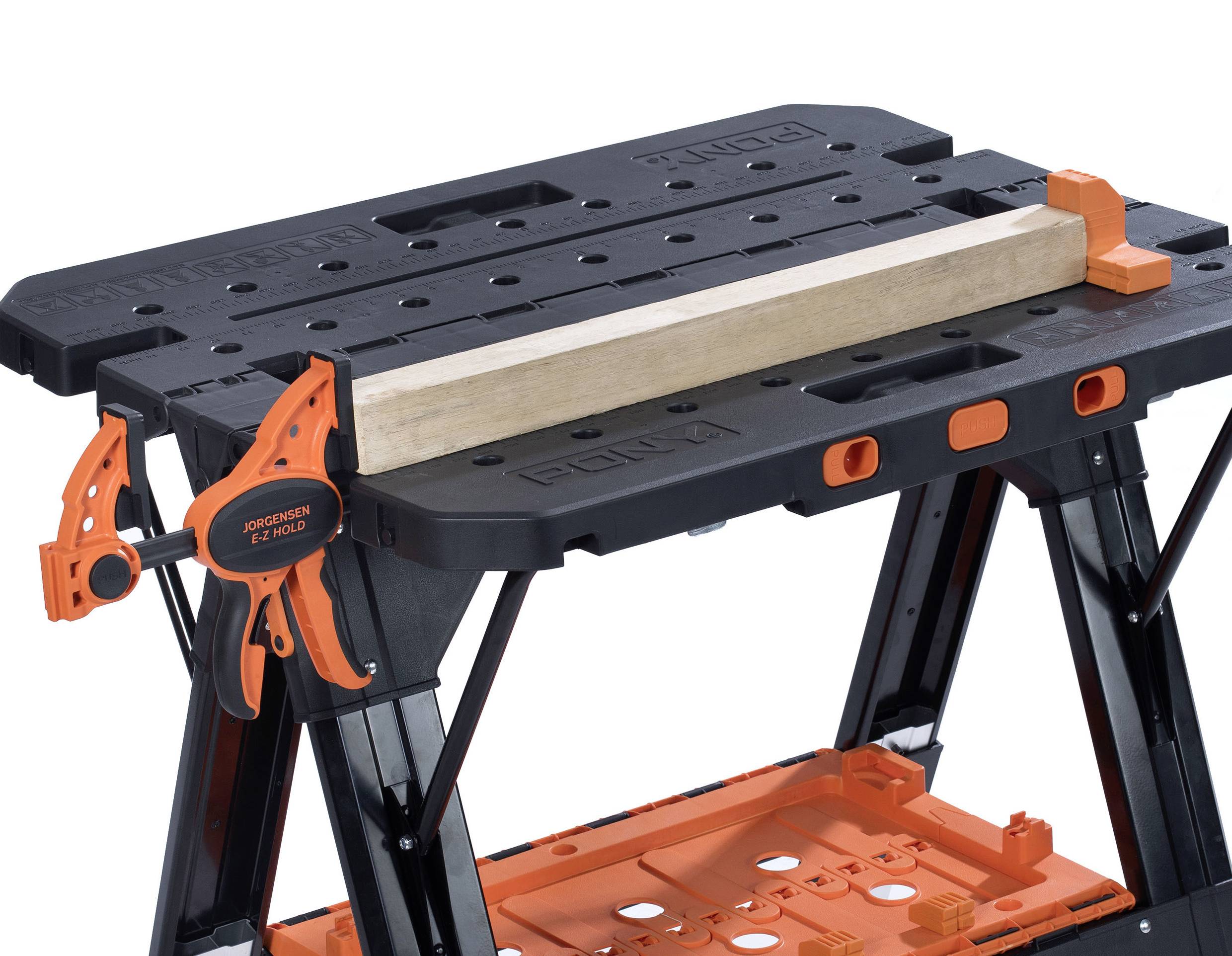 Werkbank met een zwart oppervlak, oranje gereedschapshouder en houten blok. Ideaal voor hobbyklussers en bouwprojecten.