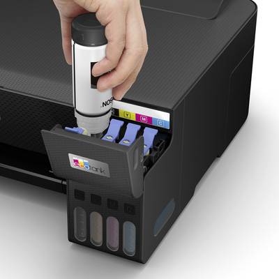 Een hand vult inkt in een printer met een kleurgecodeerd inktopslagsysteem dat de kleuren Zwart, Geel, Magenta en Cyaan toont.