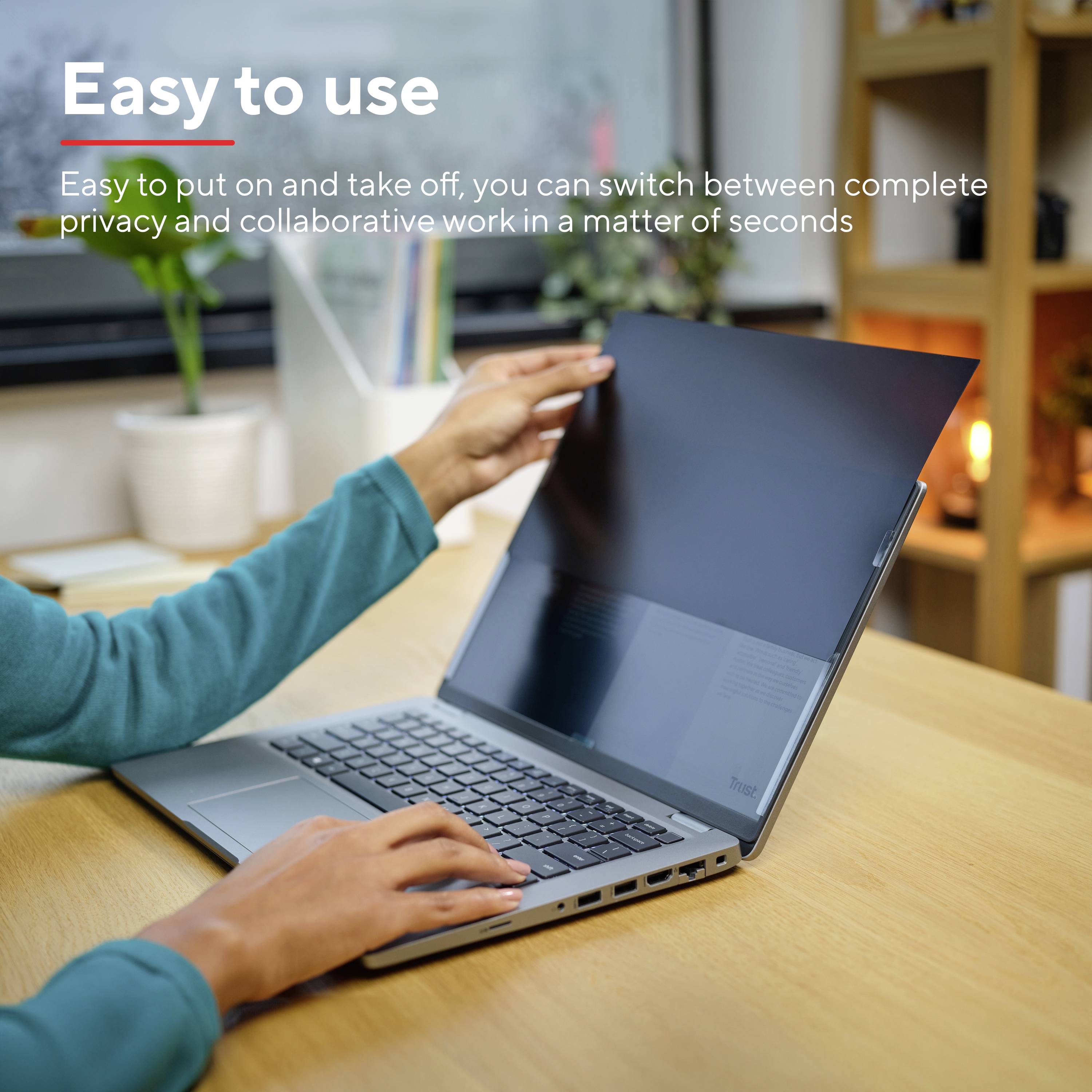 Persoon gebruikt laptop met privacyscherm dat discrete privacy waarborgt. Tekst: 'Gemakkelijk in gebruik' - bescherming snel aan te brengen en te verwijderen.