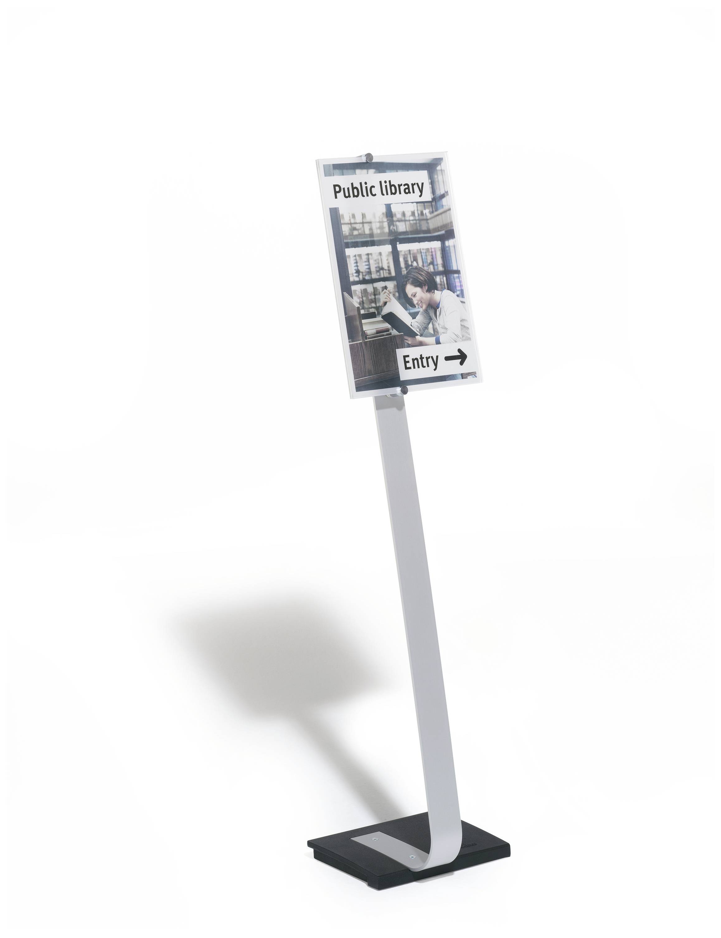 Een bord voor een openbare bibliotheek toont de aanwijzing 'Ingang' met een pijl naar rechts. Op de achtergrond zijn boekenkasten te zien.